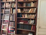 une échelle appuyée contre une bibliothèque dans un coin de la pièce