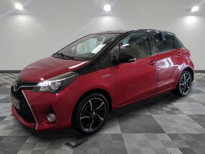 a red toyota yaris parked on a checkered tile floor