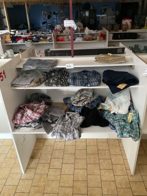 une armoire blanche sur laquelle sont posés de nombreux vêtements