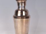 a silver and blue vase sitting on a white surface