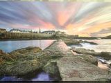 painting of a sunset over the ocean with a pier and buildings in the background