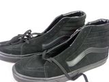 une paire de chaussures noires posées sur une surface blanche
