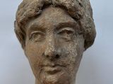 statue of a woman ' s head with short hair on a white background
