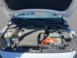 a white car with its hood open and the engine in the trunk
