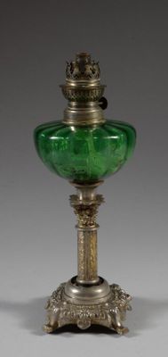 an antique silver and green glass oil lamp on a stand