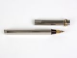 a close up of a pen and a ballpoint pen on a white surface