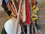 a pile of brooms and other tools on a cart