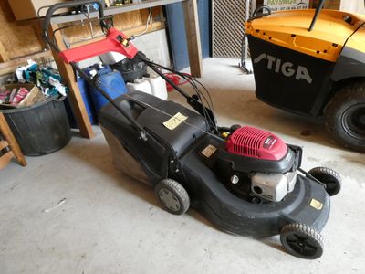 deux tondeuses à gazon garées dans un garage