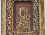 an old picture of a woman holding a child in a gold frame
