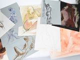 beaucoup de dessins posés sur une table, à côté d'un sac