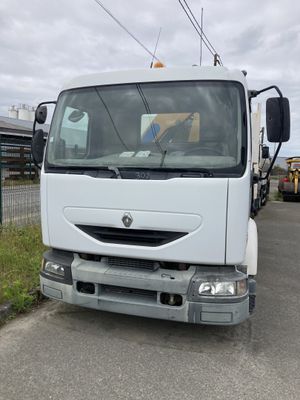 un camion blanc garé sur le bord de la route