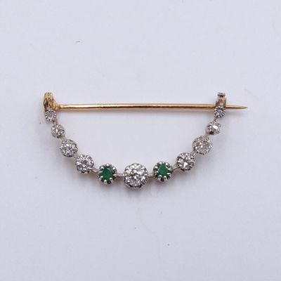 un gros plan sur une broche en forme de losange verte et blanche