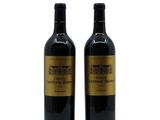 two bottles of wine sitting next to each other on a white surface