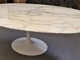 an oval marble dining table with a pedestal base