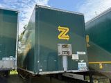 deux semi-remorques verts garés côte à côte dans un champ
