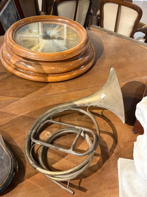 une table en bois sur laquelle se trouvent une horloge, un cor et une autre horloge