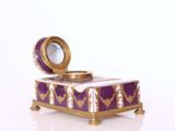 une boîte violette et dorée sur laquelle est fixé un miroir