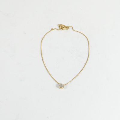 un collier en or orné d'un petit diamant blanc, monté sur une chaîne en or