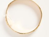 an image of a close up of a gold ring on a white surface