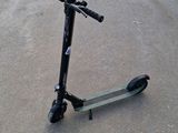 the scooter is sitting on the pavement in the parking lot