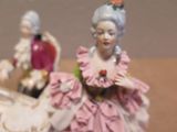 a figurine of a man and a woman sitting on a chair