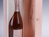the bottle of champagne is in a pink box on the table