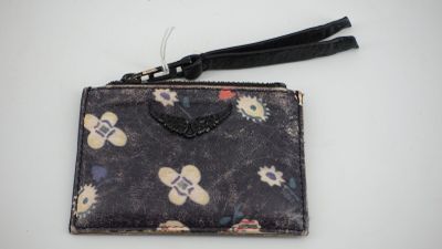un petit sac à main muni d'une fermeture éclair, posé sur une table