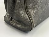a close up of a black purse on a white surface