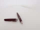 a pen and a ballpoint pen on a white surface