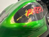 a green motorcycle with a red and yellow sticker on it