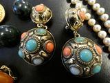 a close up of a necklace and earrings on a table