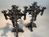 two metal candlesticks that are on a table