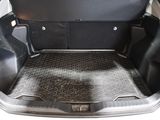a trunk of a car with a black floor mat in it