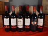 several bottles of wine are lined up in a row on a table