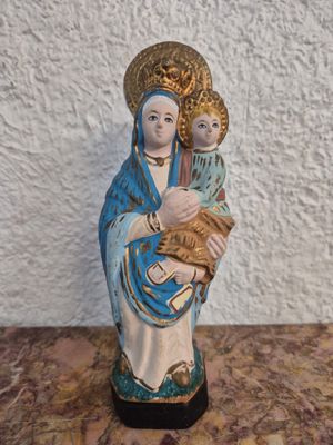 figurine représentant une femme tenant un enfant sur une table en marbre