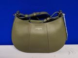 un sac à main vert muni d'une poignée en métal, posé sur une table blanche