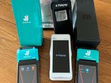 Plusieurs téléphones portables sont posés sur une table, à côté d'un verre d'eau.