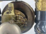 a close up of a clock with a bell on it