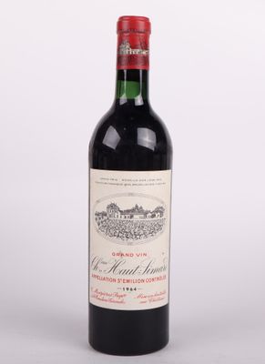 une bouteille de vin rouge posée sur une table blanche