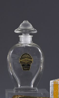a bottle of perfume and a box of oranges on a table