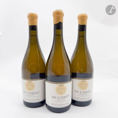 trois bouteilles de vin blanc posées sur une table blanche