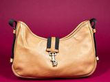 an image of a brown purse on a pink background
