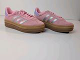 a pair of pink adidas sneakers on a white surface