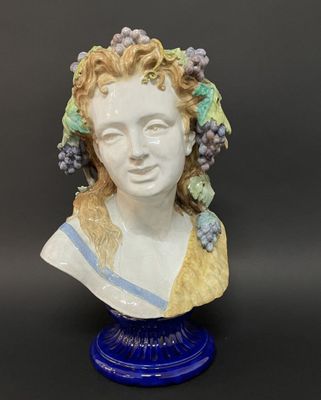 un buste en céramique représentant une femme avec des grappes de raisin sur la tête