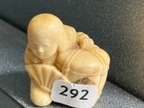 une petite figurine posée sur une étagère, avec une étiquette de prix