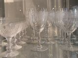 many wine glasses sitting on a glass shelf