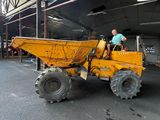 a man that is sitting in the back of a dump truck