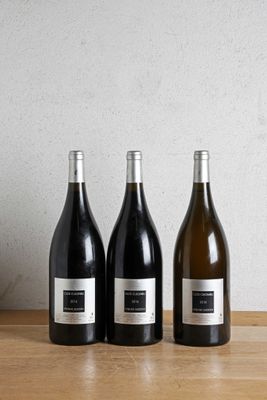 three bottles of wine sitting on top of a wooden table