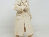 une statue représentant un homme en manteau et chapeau