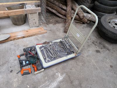 un ordinateur portable posé sur un chariot, à côté d'une pile de pneus